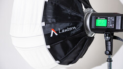 Profoto flash unit mounted on a stand with a large black and white Lantern softbox attached.