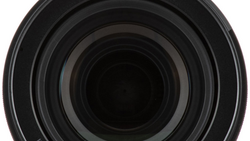 Close-up view of concentric lens elements receding into darkness, showing the optical barrel of a camera lens.