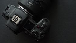 Canon EOS R5 mirrorless camera with Canon RF 70mm lens mounted, displayed on dark surface with top-down view.