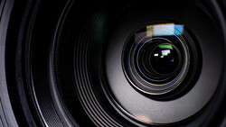 Close-up view of camera lens elements and aperture blades with internal reflections.