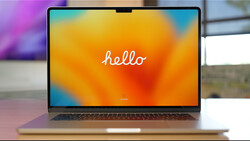 Laptop displaying a colorful gradient wallpaper with the word "hello" in white script text.