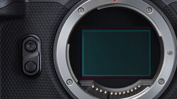 Camera body with open mirror box showing sensor and contact pins against textured grip.