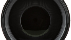 Close-up view into the barrel of a camera lens showing concentric glass elements and internal aperture mechanism.