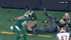 NFL players colliding during a play, with one player airborne above another on the field.