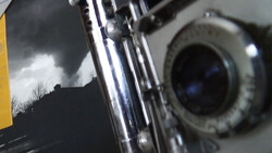 Close-up view of a motorcycle's chrome front fork and headlight against a stormy sky.