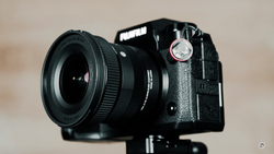 Fujifilm medium format film camera with wide-angle lens mounted on tripod against neutral background.