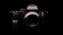 Sony a7 III mirrorless camera body with FE 2.8/35 lens mounted, photographed against black background.
