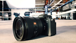 Sony α9 mirrorless camera with G-series lens on concrete surface in modern building.