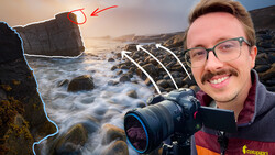 Photographer holding mirrorless camera at rocky coastal location during golden hour with waves and stone formations.