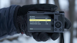 Camera LCD screen displaying ISO settings menu with AUTO mode selected and lower limit set to 100.