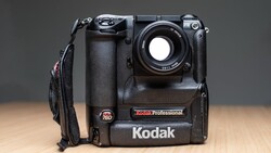 Kodak Professional digital camera with battery grip and attached lens strap, displayed against neutral background.