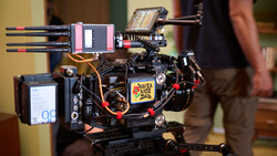 Compact cinema camera rig with mounted monitor, wireless follow focus, and professional accessories on support frame.