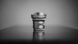 Wide-angle lens with prominent front element and focus ring, photographed against neutral background.