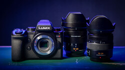 Panasonic Lumix G9II camera body with two interchangeable lenses arranged on a blue-lit surface.