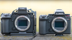 Panasonic Lumix S5II camera body next to a Smallrig-rigged camera of larger format on concrete surface.