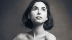 Black and white portrait of a woman with shoulder-length dark hair, looking upward with a contemplative expression.