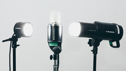 Three studio flash units mounted on stands against a white background.