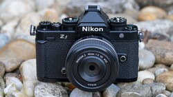 Nikon Z f mirrorless camera with 40mm f/2 lens on rocky ground backdrop.