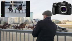 Photographer capturing harness racing from a bridge railing with a mirrorless camera.