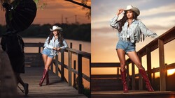 Woman in cowboy hat and denim shorts posing on wooden deck at golden hour sunset.