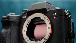 Sony α7R mirrorless camera body with open shutter, showing red sensor contacts against blue background.