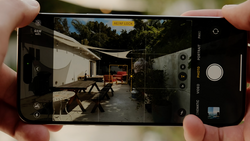 Screenshot of iPhone camera app displaying a residential courtyard with portrait mode active.