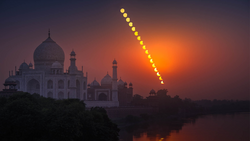 Taj Mahal silhouetted against dramatic orange sunset sky with diagonal line of bright spots overlaid.