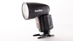 Godox speedlight flash with reflector attachment and stand foot against white background.