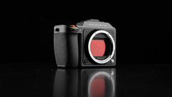 Hasselblad mirrorless camera body with exposed sensor against black background.