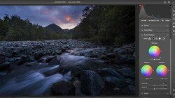 Screenshot of photo editing software showing a long-exposure landscape photograph of a rocky river at dusk.