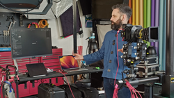 Filmmaker operating a cinema camera on a motorized rig in a professional studio setup.