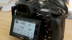 Nikon DSLR camera displaying exposure settings on rear LCD screen with 1/400 shutter speed and F4 aperture visible.
