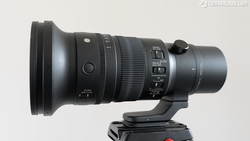 Telephoto lens with focus ring and aperture controls mounted on tripod head.