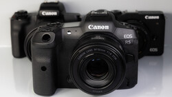Canon EOS R5 mirrorless camera with RF 50mm lens in front of other Canon camera bodies.