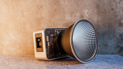 Vintage instant camera with detached flash unit positioned on weathered surface.