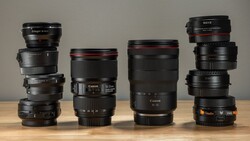 Four stacked camera lenses of varying focal lengths arranged in ascending height order against a neutral background.
