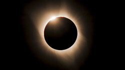 Total solar eclipse with the moon blocking the sun's disk and the solar corona glowing brightly around it against a dark sky.