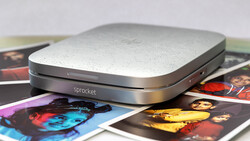 Sprocket portable photo printer positioned on colorful printed photographs.