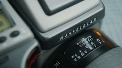Close-up of Hasselblad camera body showing lens aperture ring and shutter speed dial.