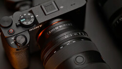 Sony mirrorless camera with attached lens shown from above on dark surface.