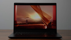 Laptop displaying a sunset landscape with warm golden light and silhouetted foreground elements.