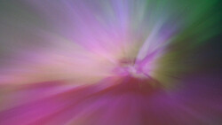 Abstract radial blur with magenta, green, and purple light rays converging toward center.