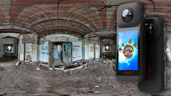 360-degree camera device displayed next to an expansive panoramic photograph of an abandoned, deteriorating interior space.