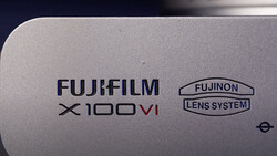 Close-up of Fujifilm X100VI camera body showing branding and Fujinon lens system marking.