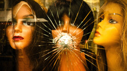 Two women's faces flanking a shattered glass center with radiating light rays.