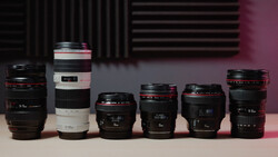 Six camera lenses arranged in a line, displaying varying focal lengths and designs against a pink and dark background.