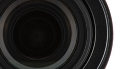 Close-up view of camera lens elements showing concentric glass rings and optical coatings.