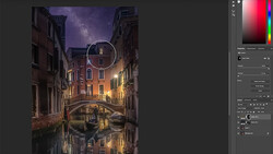Venice canal at night with illuminated buildings, starry sky, and gondola reflection in still water.