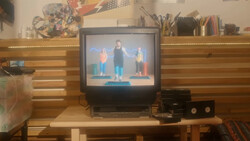 CRT television displaying three people standing on a blue platform against a blue background.