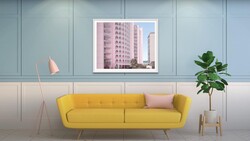 Modern interior design render featuring a yellow sofa against paneled walls with framed architectural photography.